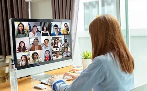 kursy-zdalne-w-coders-lab Kobieta siedzi przed komputerem i ma zajęcia w Wirtualnej Klasie na zdalnym kursie programowania.