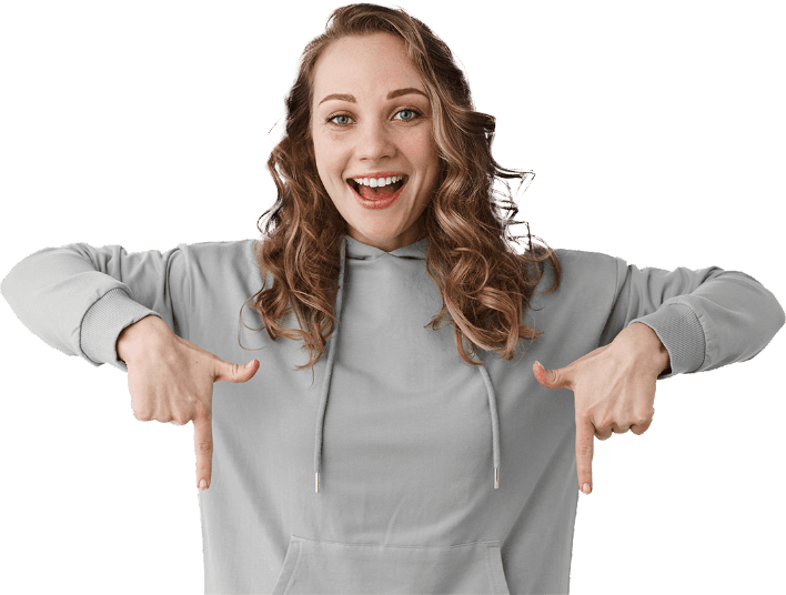 positive-smiling-girl-with-blond-hair-pointing-fingers-down-inviting-click-link-showing-advertisement-standing-green-hoodie-against-white-background.png